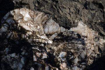 Quartz vein in volcanic rock formations under bright sunlight