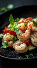 Shrimp and vegetable salad on a black plate on a black background.