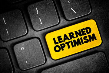 Fototapeta premium Learned Optimism - developing the ability to view the world from a positive point of view, text button on keyboard, concept background