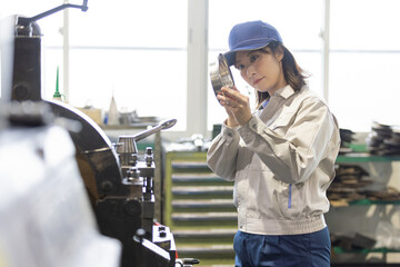工場で旋盤加工品・フライス加工品を確認する作業員