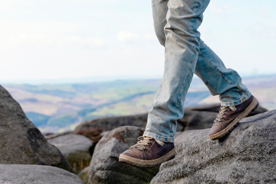 Hiker walks on rocky terrain in scenic landscape during a sunny day