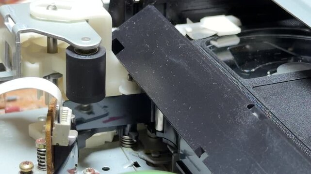 The internal gears of a VCR pull the cassette into place with a heavy mechanical click. As the tape begins to spin, it produces a continuous, high-pitched whirring sound.