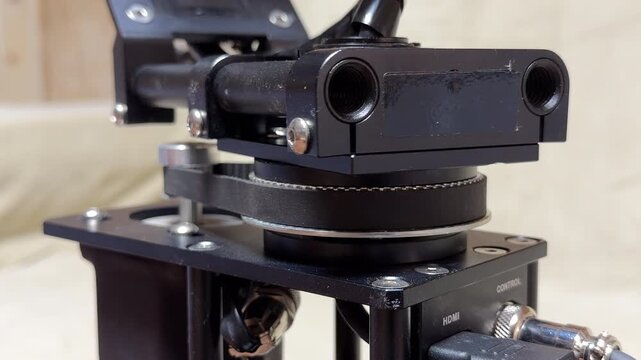 The motorized camera gimbal rotates its belt-driven axis to maintain perfect balance. This robotic movement creates a high-pitched technical whir and a faint, rhythmic mechanical hum.