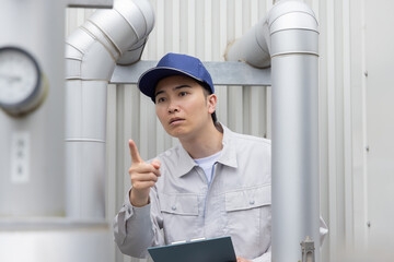 屋外機械を点検する男性作業員