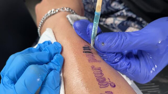 Unrecognizable Thai traditional sak yant bamboo tattoo lettering handpoked close up.