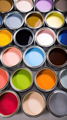 Fototapeta premium An overhead view of numerous open paint cans filled with various vibrant and muted colors arranged in a grid pattern.