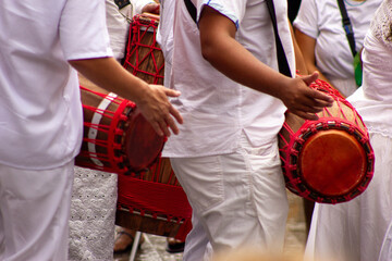 Mãos de homens negros tocando atabaque instrumento usado em rituais da umbanda. 
