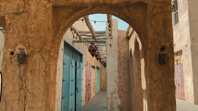 Scenic views of Dubai's Al Seef heritage district featuring traditional Arabian architecture, wind towers, narrow alleyways, and waterfront scenery along the creek during a sunny day.

