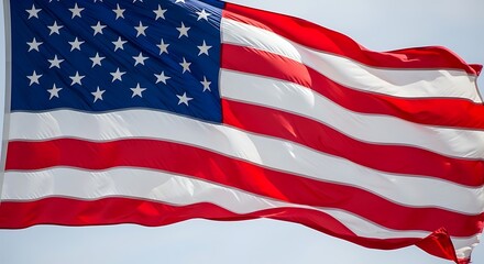 Obraz premium The American flag waving proudly in the wind against a clear sky