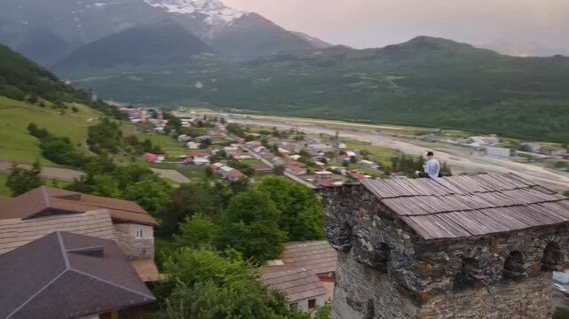 Aerial drone glides over Ushguli and Mestia in Upper Svaneti, Georgia, revealing medieval Svan towers, a braided riverbed, fields, terraces, and snow capped Caucasus peaks.