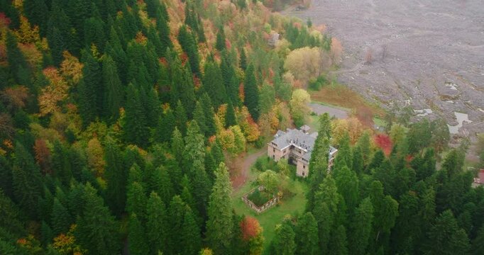 Historical Stalin's summer house in the forest of Racha-Lechkhumi, Georgia. Aerial camera performs a dolly-in movement towards the building surrounded by autumn colors.