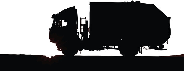 Obraz premium Large refuse truck silhouette drives along a textured, dark road surface under a brilliant white sky.