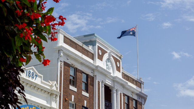 Heritage Architecture of Sydney Council Building 1887 with Australian National Flag Flying under Blue Sky