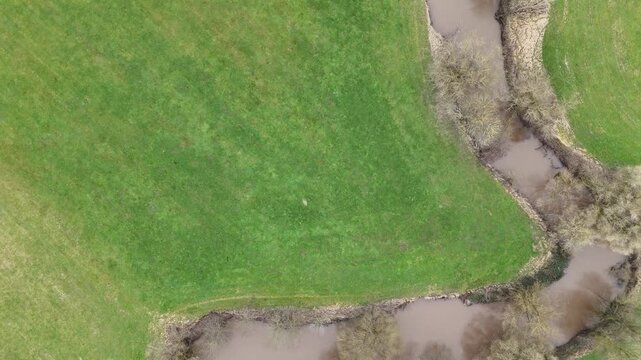 Aerial Drone Flight Along a Winding River Through Rural Farmland	
