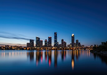 Fototapeta premium Modern City Skyline Reflected in Calm Water at Dusk