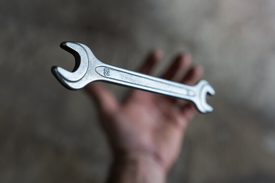 The mechanic throws the wrench out of his hand and it goes into free fall.