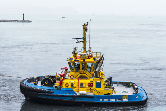 Callao, Peru - a tugboat navigates near container terminal, she is about to assist to the cargo ship during arrival maneuverings.  