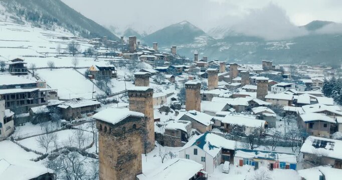 Aerial view of Mestia village and historic Svan towers under snow, Georgia. Winter landscape in Caucasus Mountains.