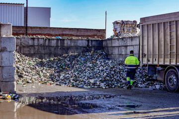 Industrial truck unloading glass bottles for recycling at a processing plant. © JuanFrancisco