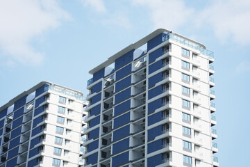 Fototapeta premium Modern high-rise residential buildings with blue and white facades captured from a low-angle perspective