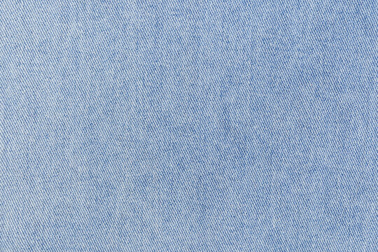 Light denim fabric closeup showing indigo weave and fine threads, subtle faded wash, cotton texture for heritage denim styling, product background or textile mockup for sustainable fashion campaigns