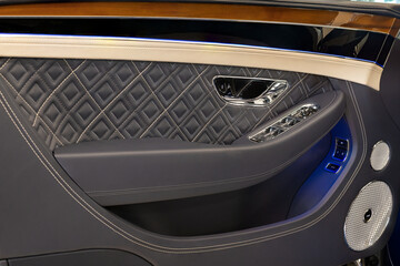Obraz premium Close-up of a Bentley Continental GT luxury door panel featuring quilted leather upholstery and Naim sound system