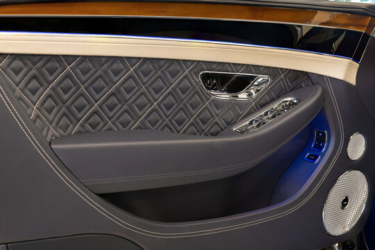 Close-up of a Bentley Continental GT luxury door panel featuring quilted leather upholstery and Naim sound system