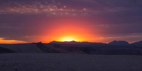 A serene desert landscape at sunset with mountains in the distance