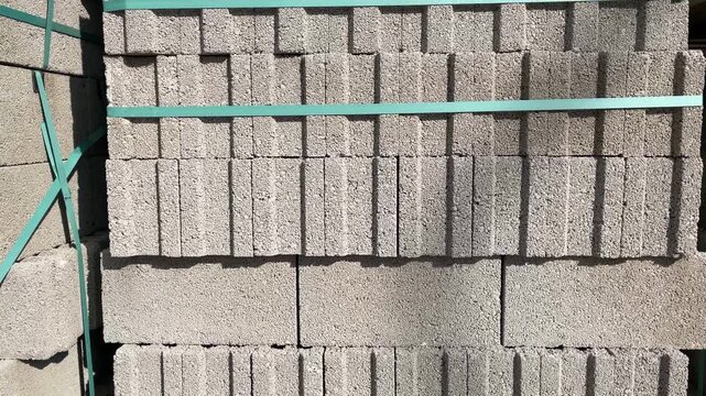 Concrete blocks stacked in sunlight creating a textured industrial background