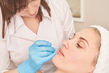 Naklejka premium Female caucasian adult undergoing cosmetic skin procedure in spa setting with focus on beauty and care.