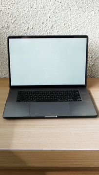 Modern Space Gray MacBook Pro Mockup on Minimalist Wooden Desk with Blank Screen