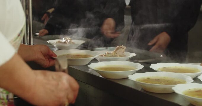 Cafeteria Worker Serving Hot Soup to Students in School Canteen