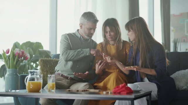 Parents and child planning together, Family enjoying sunny breakfast with digital device interaction and smiles