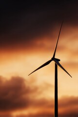 Obraz premium wind turbine silhouette at golden sunrise, renewable energy and nature harmony