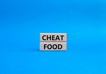 Obraz premium Cheat Food symbol. Wooden blocks with words Cheat Food. Beautiful blue background. Health and Cheat Food concept. Copy space.