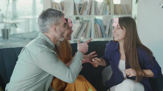 Office team engaging in game, Casual coworkers participating in lighthearted guessing game during break
