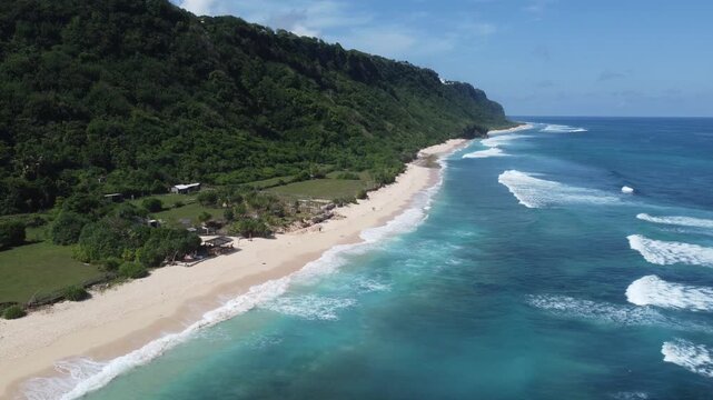 Aerial drone standstill hover above coastline away from beach entrance and cliffs at Nyang Nyang Beach, Bali Indonesia
