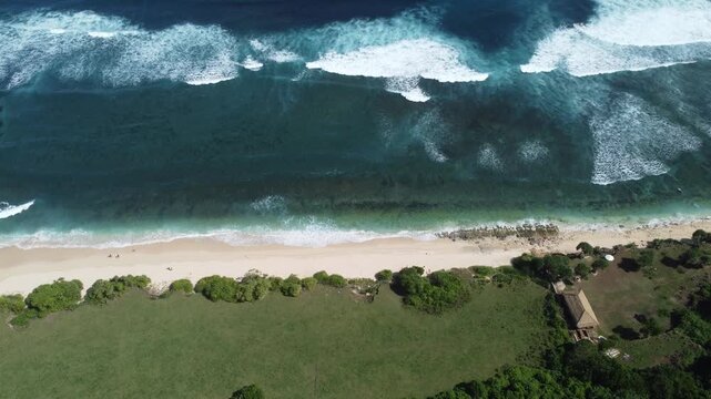 Aerial drone standstill hover above coastline towards beach and water at Nyang Nyang Beach, Bali Indonesia