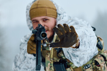 Obraz premium Soldier in White Snow Camo Aiming Rifle in Winter Forest Tactical Portrait
