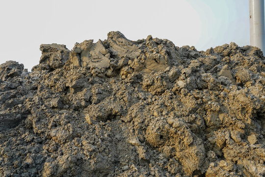 pile of dry clumpy earth with textured surface and light sky