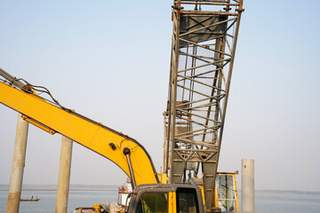 yellow excavator boom and crane tower at construction site © Tohamina
