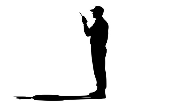 Silhouette of a Person with a Walkie-Talkie: A stark silhouette of a man holding a walkie-talkie, his profile cast against a bright, airy backdrop. This image embodies communication, industry.