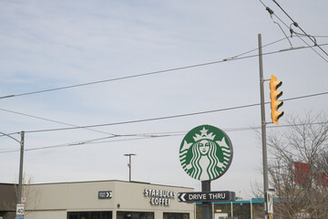 Fototapeta premium wide distant view of round road side mermaid logo sign of Starbucks Coffee Company located here at 23 Leslie St, Toronto