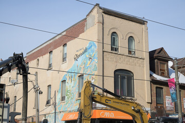 Fototapeta premium construction equipment outside Oma Chiropractic & Wellness located at 1 Munro St at Queen St E, in Riverdale neighborhood, Toronto