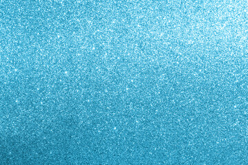 Turquoise glitter background with sparkling shimmer, texture and soft light-to-dark gradient
