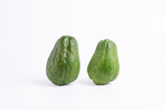 Two fresh green chayote or sechium edule isolated on white background. Raw organic vegetable pair for healthy cooking ingredient.
