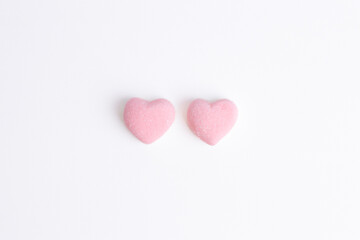 Fototapeta premium Two pink heart shaped gummy candies isolated on white. Sweet sugar jelly snack for valentine day love gift. 