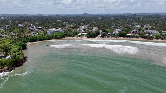 Galle, Sri Lanka, November 3, 2025: Devata Beach in the galle city and surfers riding in the waves