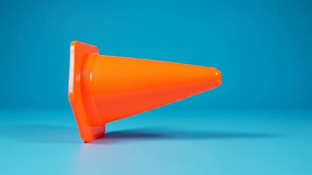 Bright Orange Traffic Cone on Blue Background - A Study in Simplicity and Safety.