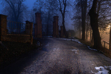 Cmentarz komunalny w mieście Żagań w Polsce. Brama główna w mglisty, zimowy wieczór. © boguslavus